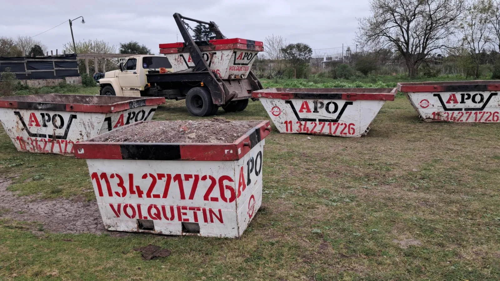 Volquetín APO cargado de tierra, con volquetes grandes y el camión detrás