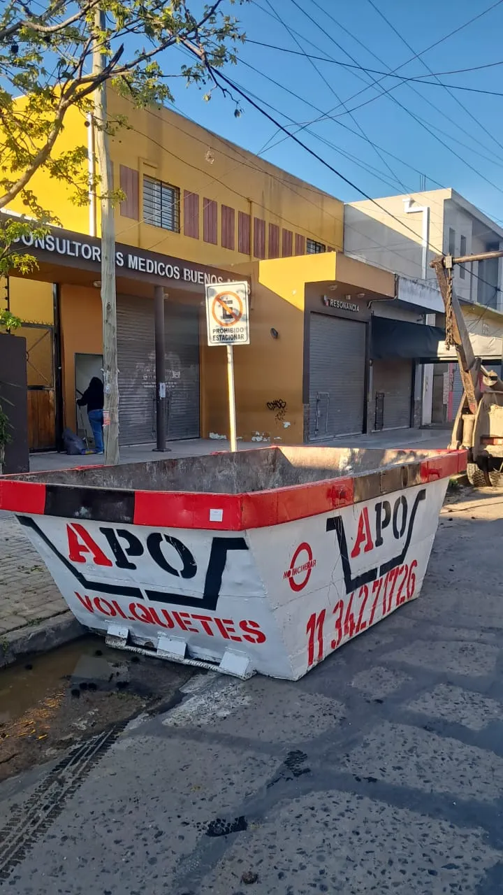Volquete APO en la calle frente a un local comercial